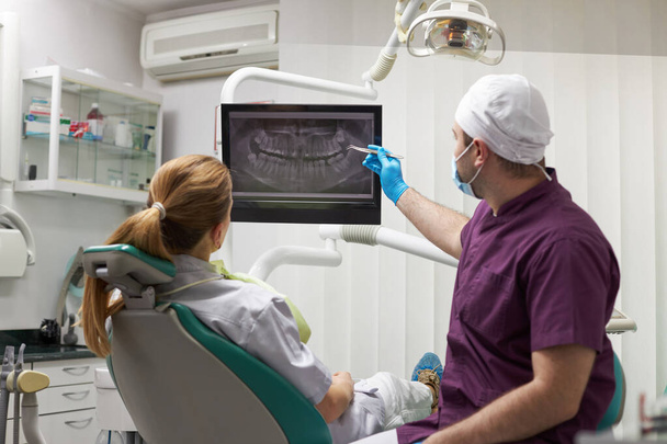 dentist explains on digital x ray orthopantomogram, the treatment that needs to be done in clinic
